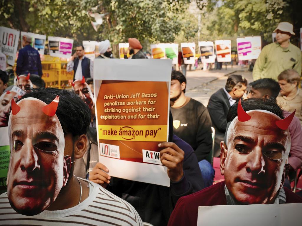 Participants wear paper masks in the likeness of Amazon's Jeff Bezos