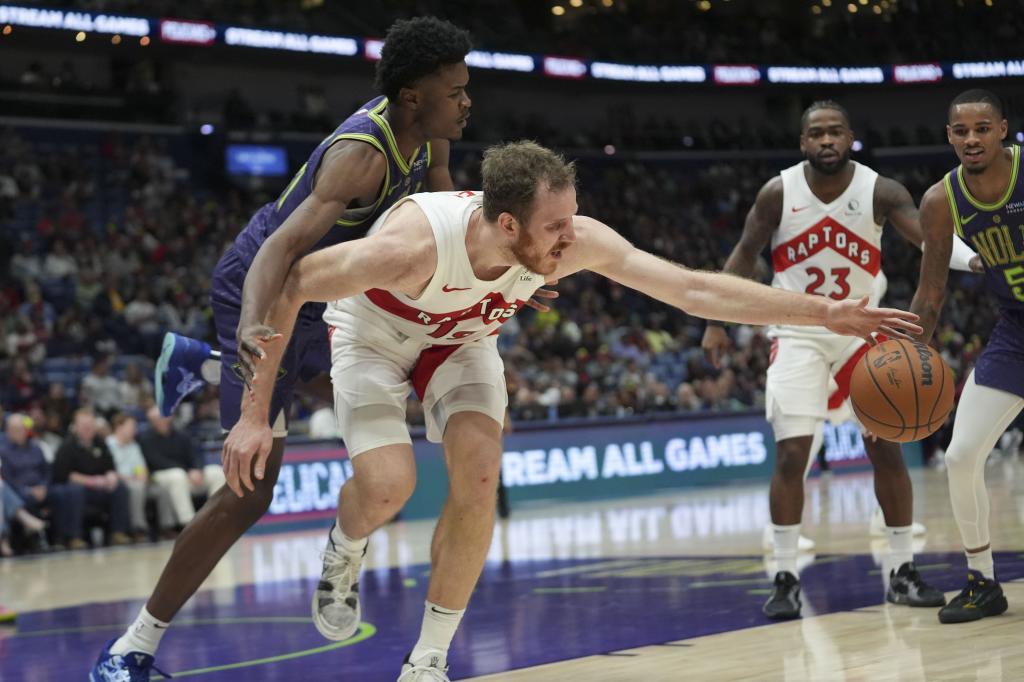 Toronto Raptors center Jakob Poeltl chases down loose ball against New Orleans Pelicans center Yves Missi