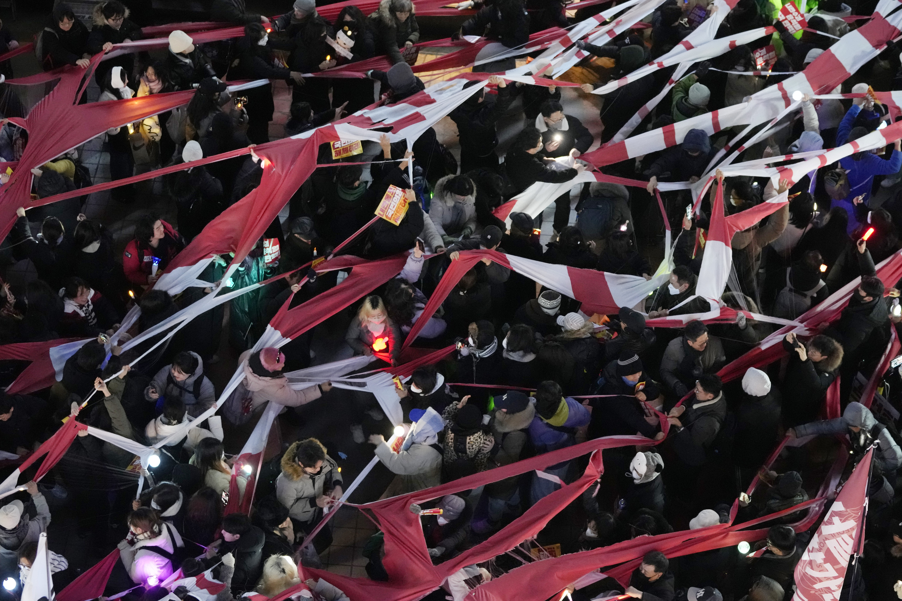 Participants tear a banner representing the flag of the ruling People Power Party during a rally to demand South Korean President Yoon Suk Yeol's impeachment.