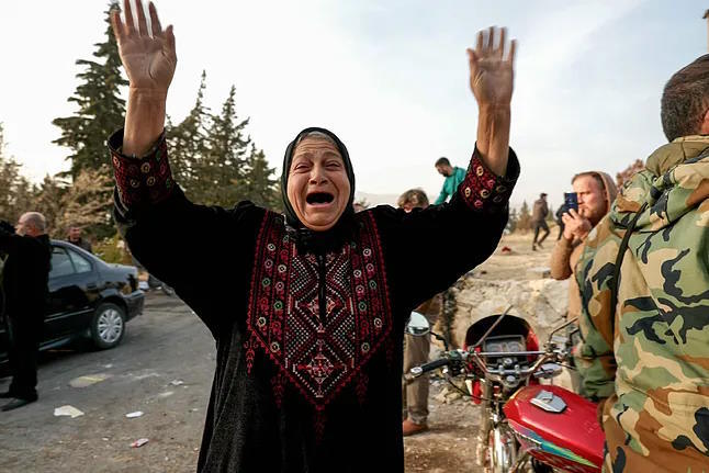 A woman searches for her relatives at the gates of the Sednaya prison.