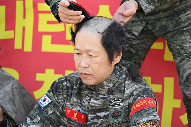 A veteran shaves his head in protest after the declaration of martial law.