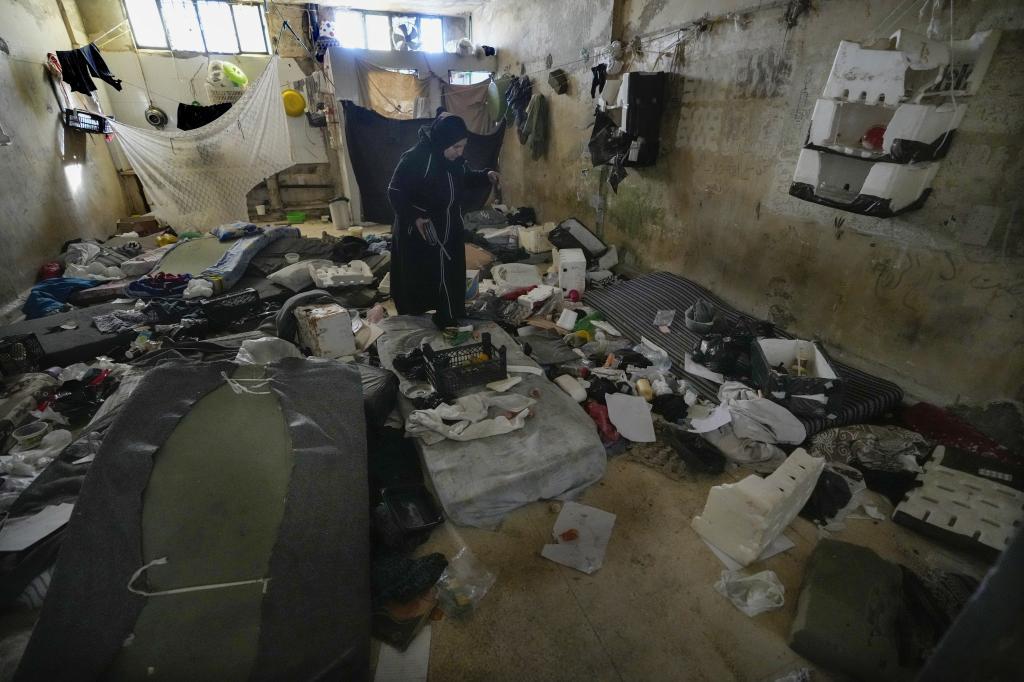 A woman looks at a room of the infamous Saydnaya military prison, just north of Damascus, Syria,