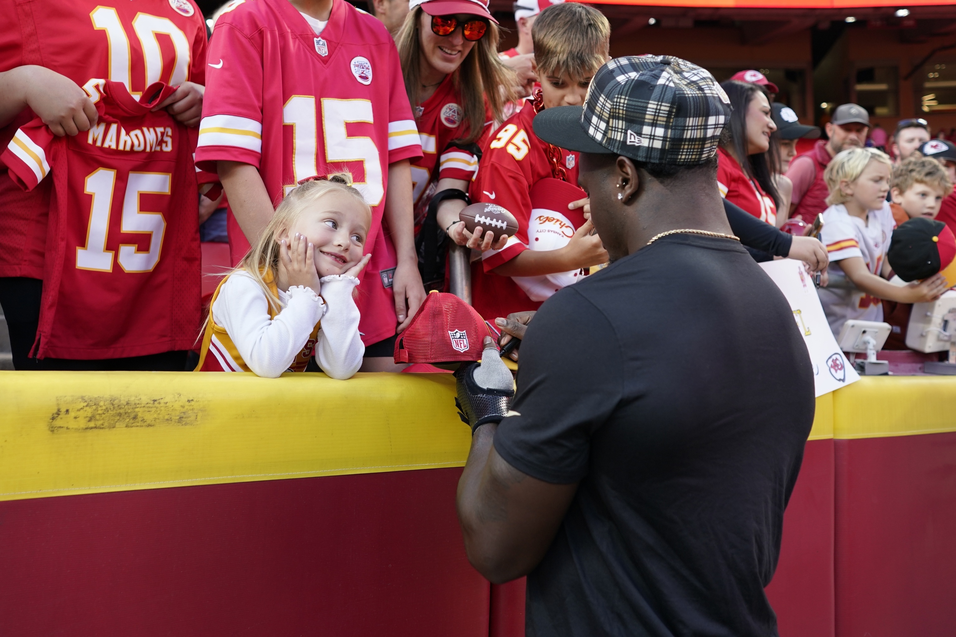 New Orleans Saints linebacker Willie Gay Jr. signs autographs for a young fan before the start of an NFL football.