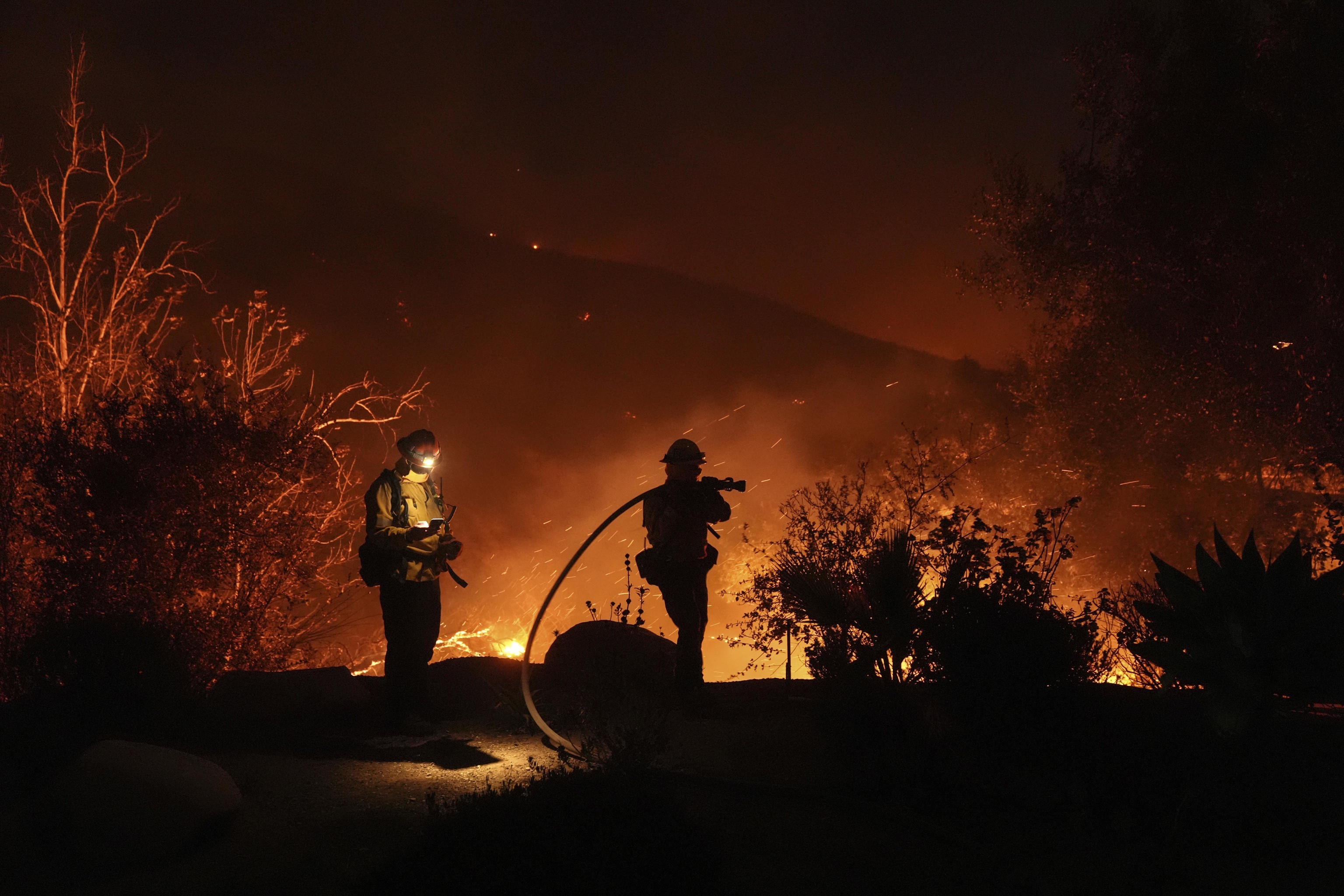 Firefighters battle the flames of the Malibu fire.