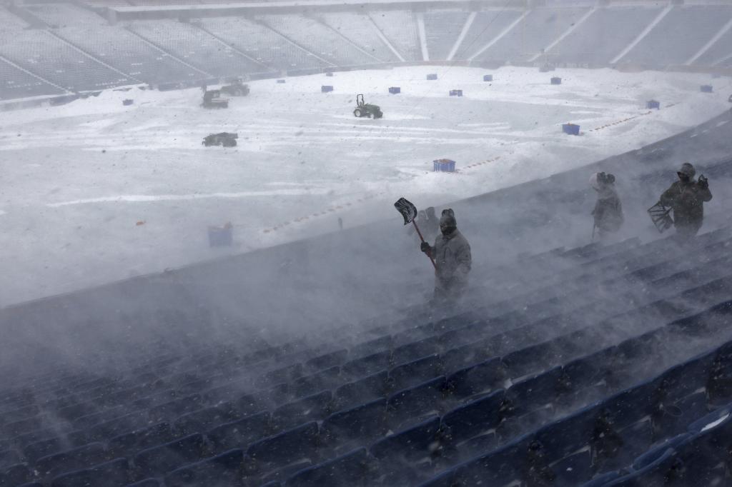 Workers remove snow from Highmark Stadium in Orchard Park