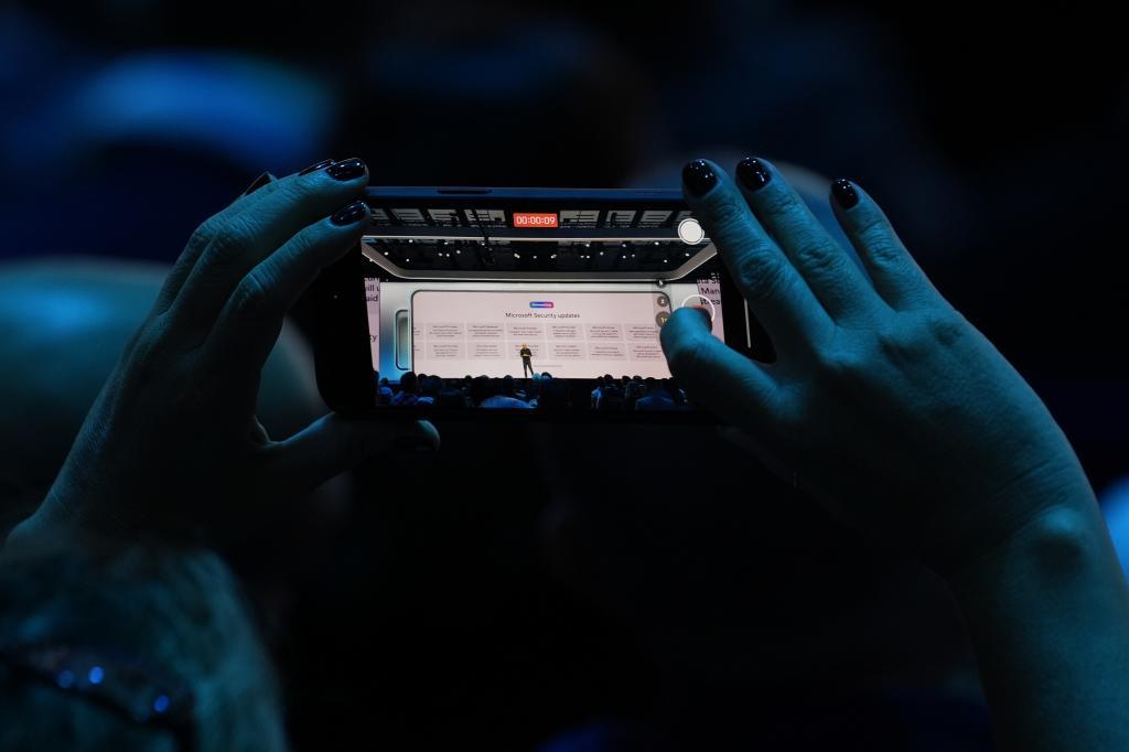 An attendee at the Microsoft Ignite conference records an address on Nov. 19, 2024, in Chicago