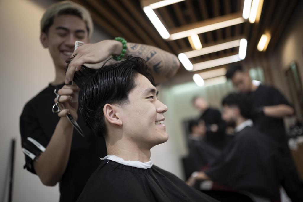 Barbers work on their clients at 12 Pell, a local barbershop in Manhattan's Chinatown