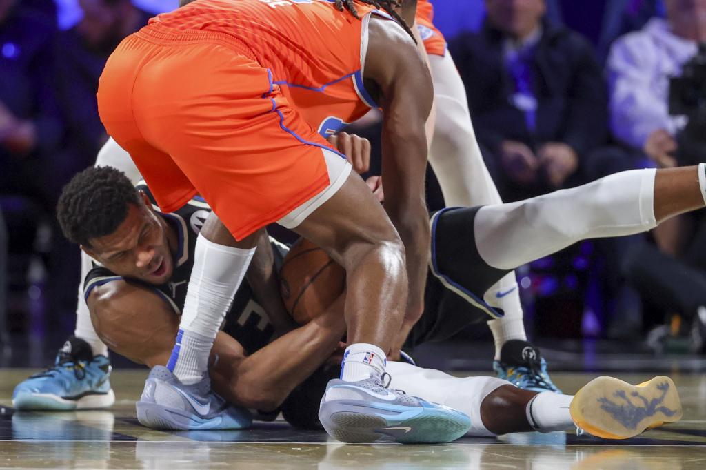 Milwaukee Bucks forward Giannis Antetokounmpo (34) wrestles for a loose ball with Oklahoma City Thunder guard Cason Wallace (22)