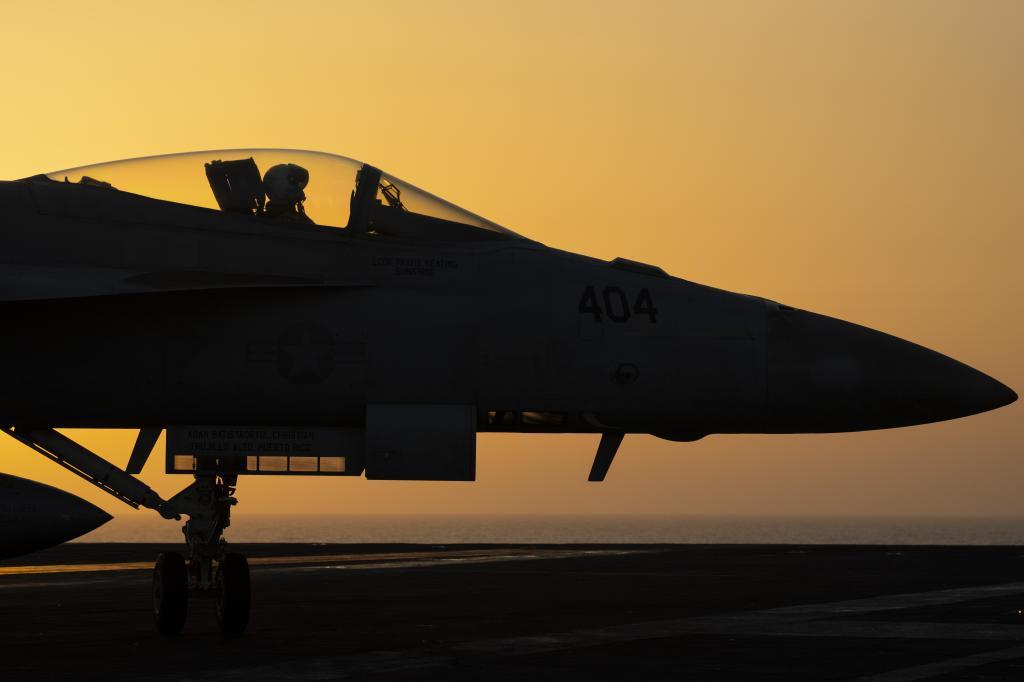 A fighter aircraft performs maneuvers on the platform of the aircraft carrier USS Dwight D. Eisenhower.