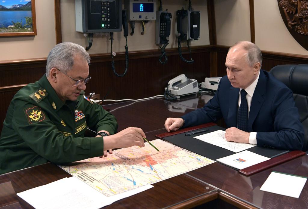 Russian President Vladimir Putin, right, listens to Russian Defense Minister Sergei Shoigu