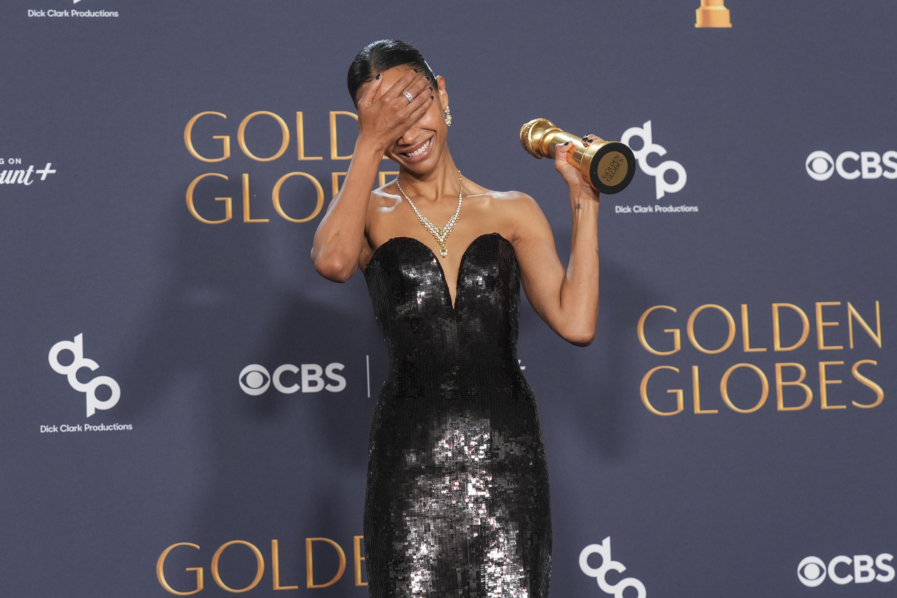 Zoe Saldana poses with the award for best performance by a female actor.