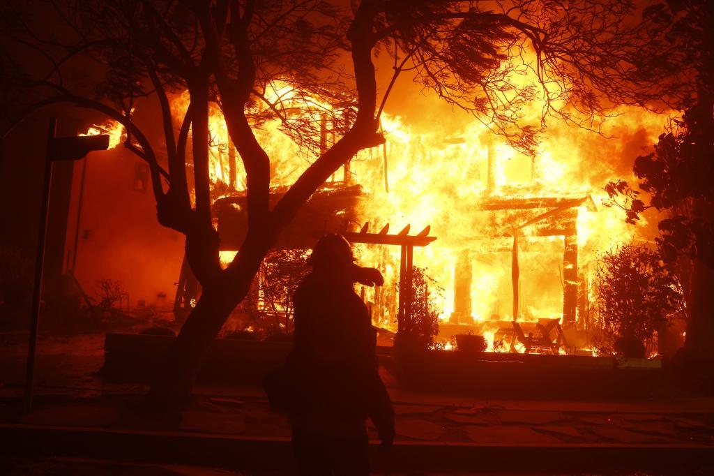 A firefighter battles the Palisades Fire in the Pacific Palisades neighborhood of Los Angeles