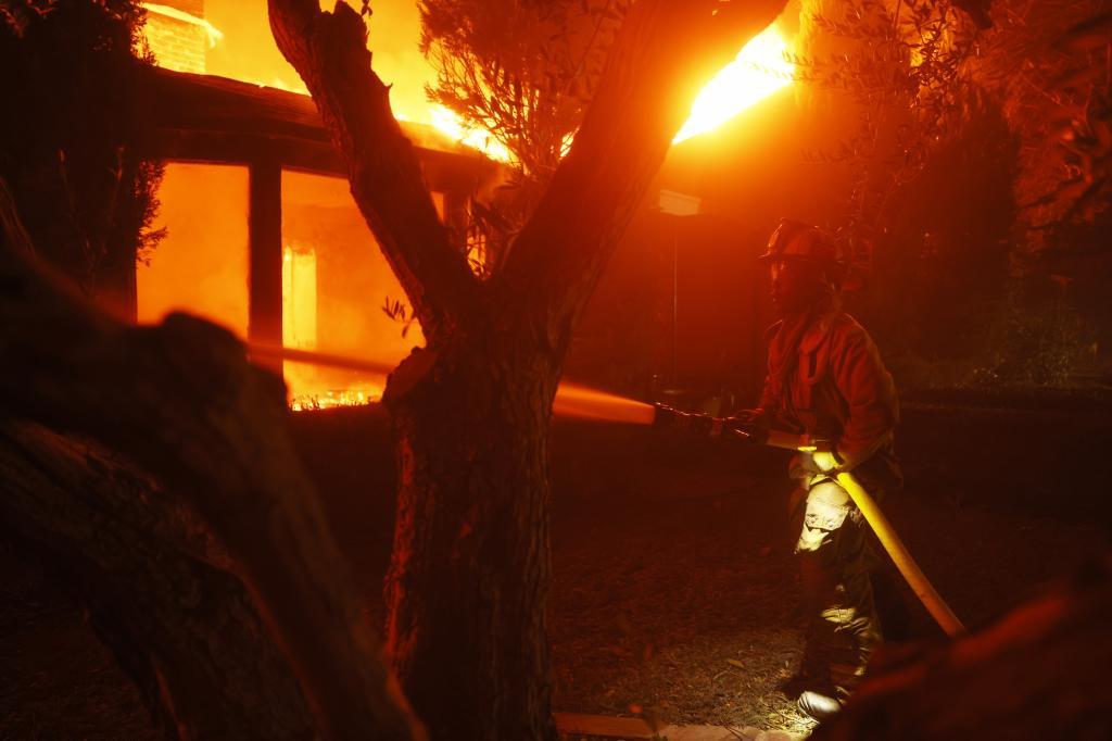 A firefighter battles the Palisades Fire in the Pacific Palisades neighborhood of Los Angeles