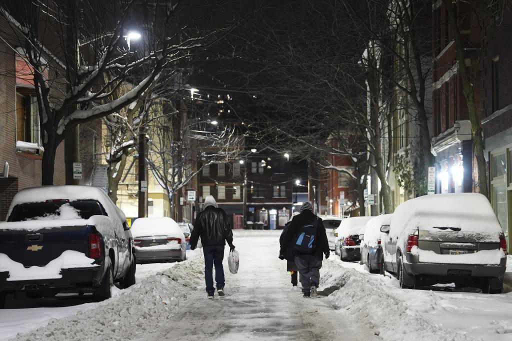 Unhoused people walk down a street toward a shelter in Cincinnati.