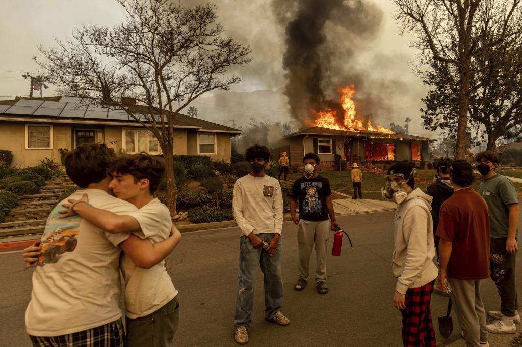 Residents embrace outside of a burning property