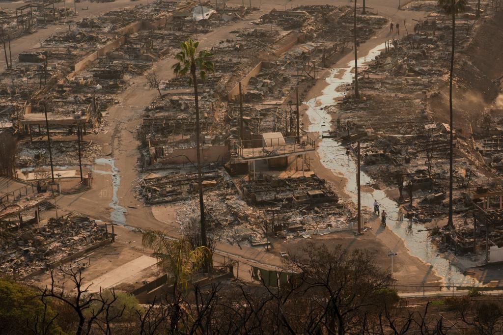 A person walks amid the destruction left behind by the Palisades Fire in the Pacific Palisades neighborhood of Los Angeles