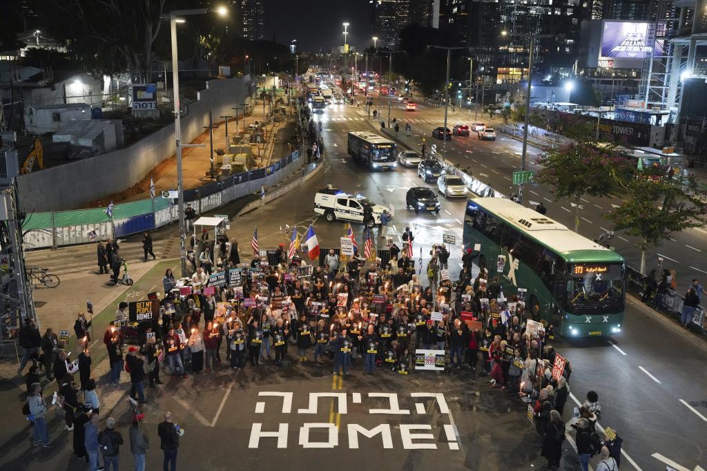 Demonstrators hold torches during a protest calling for the immediate release of the hostages held in the Gaza Strip by the Hamas militant group in Tel Aviv