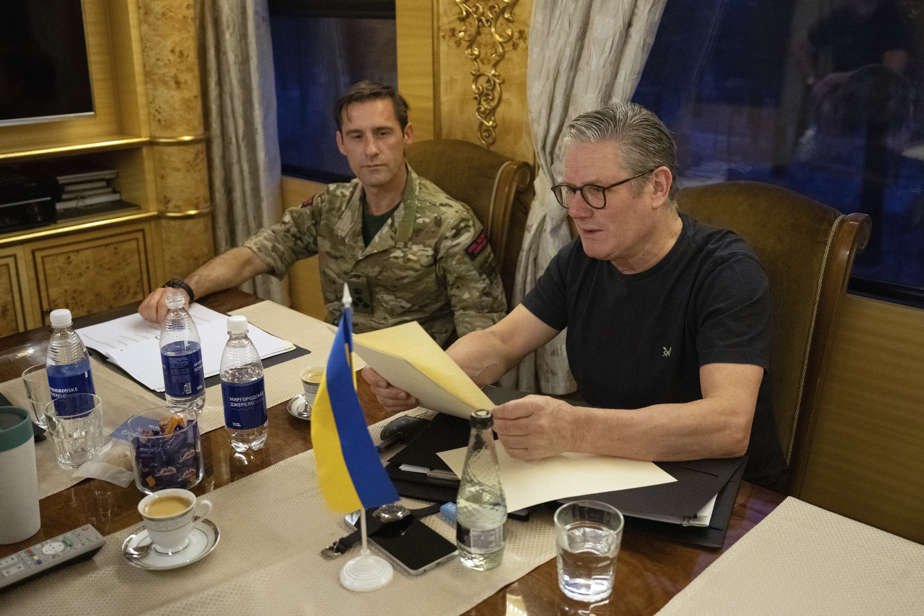 British Prime Minister Keir Starmer, right, is briefed by his unidentified military assistant on a train bound for Kyiv.