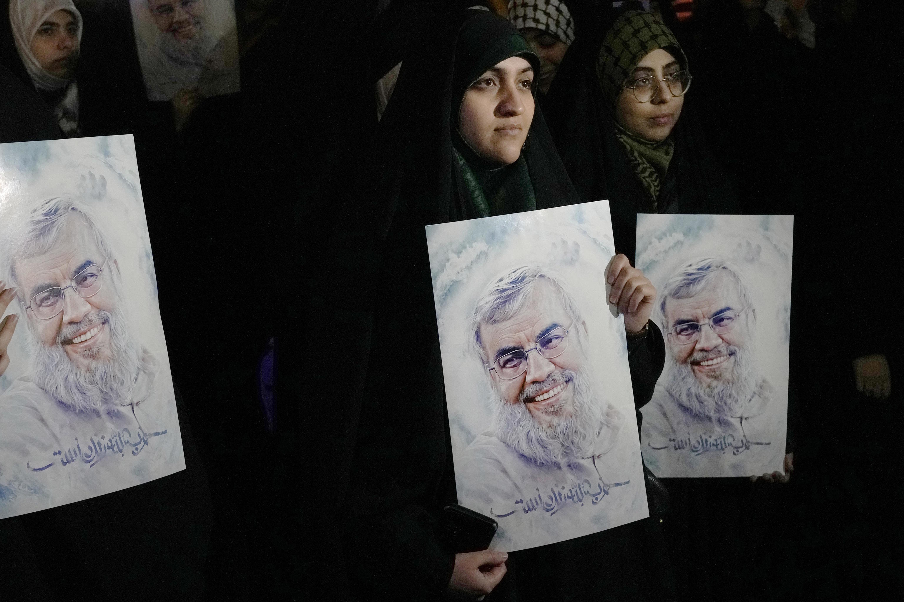 Iranian demonstrators hold posters of the slain Hezbollah leader Nasrallah.