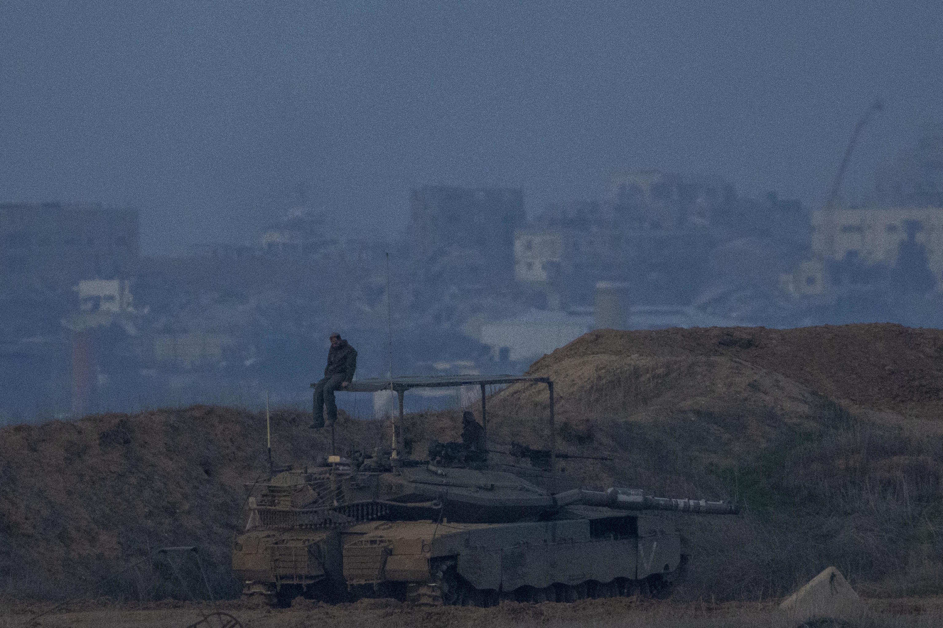 An Israeli soldier sits on a tank on the border with Gaza.