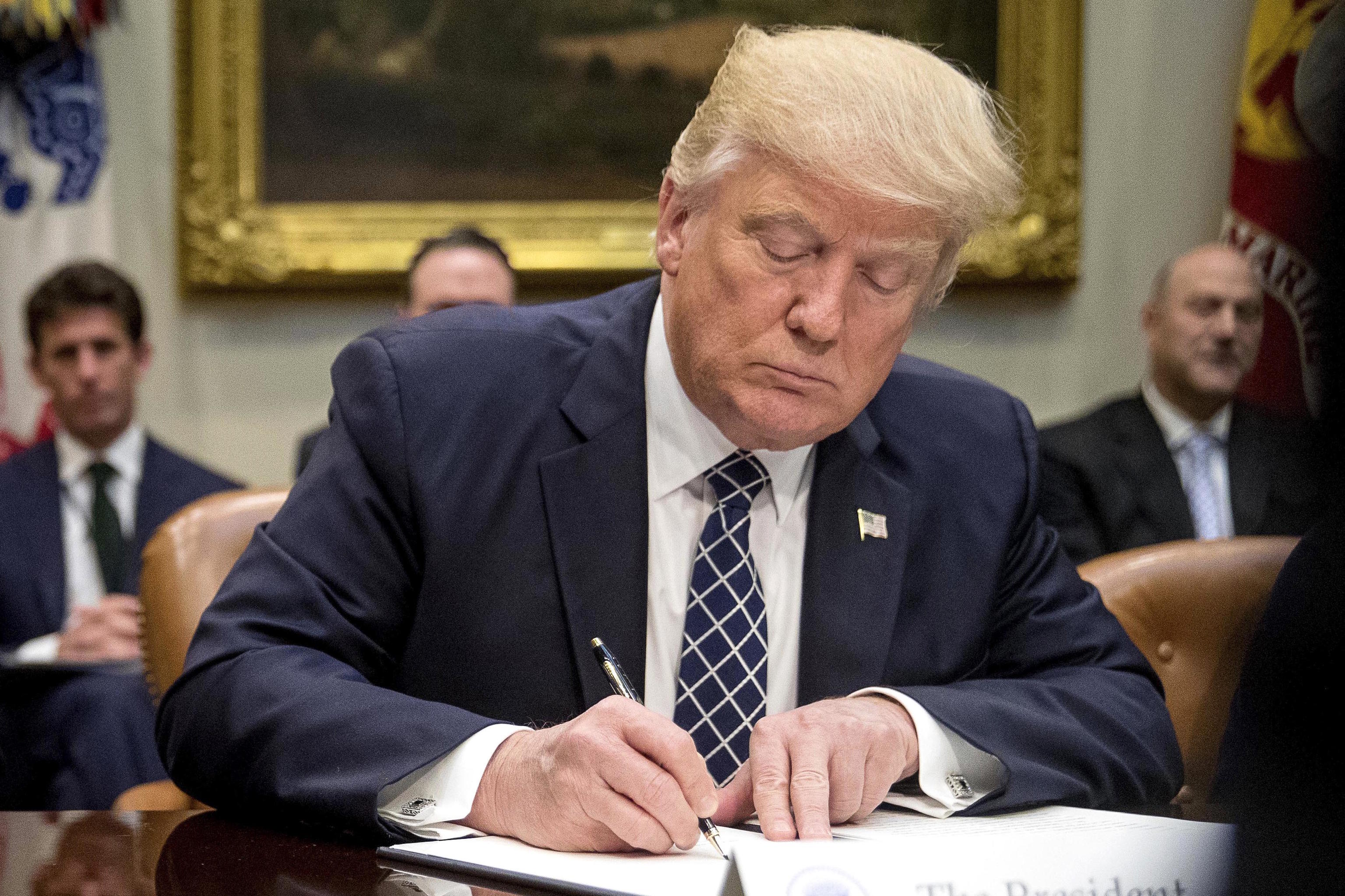 President Donald Trump signs an executive order.