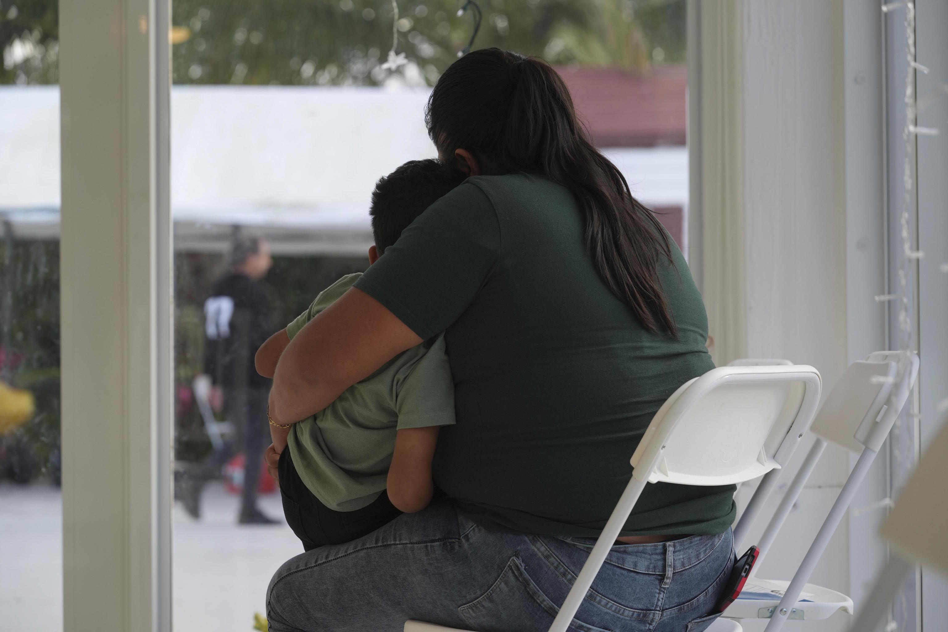 A mother embraces her son.