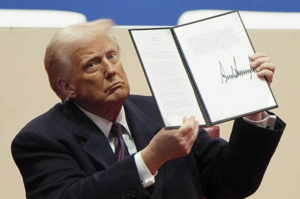 U.S. President Donald Trump holds up an executive order signed after his inauguration