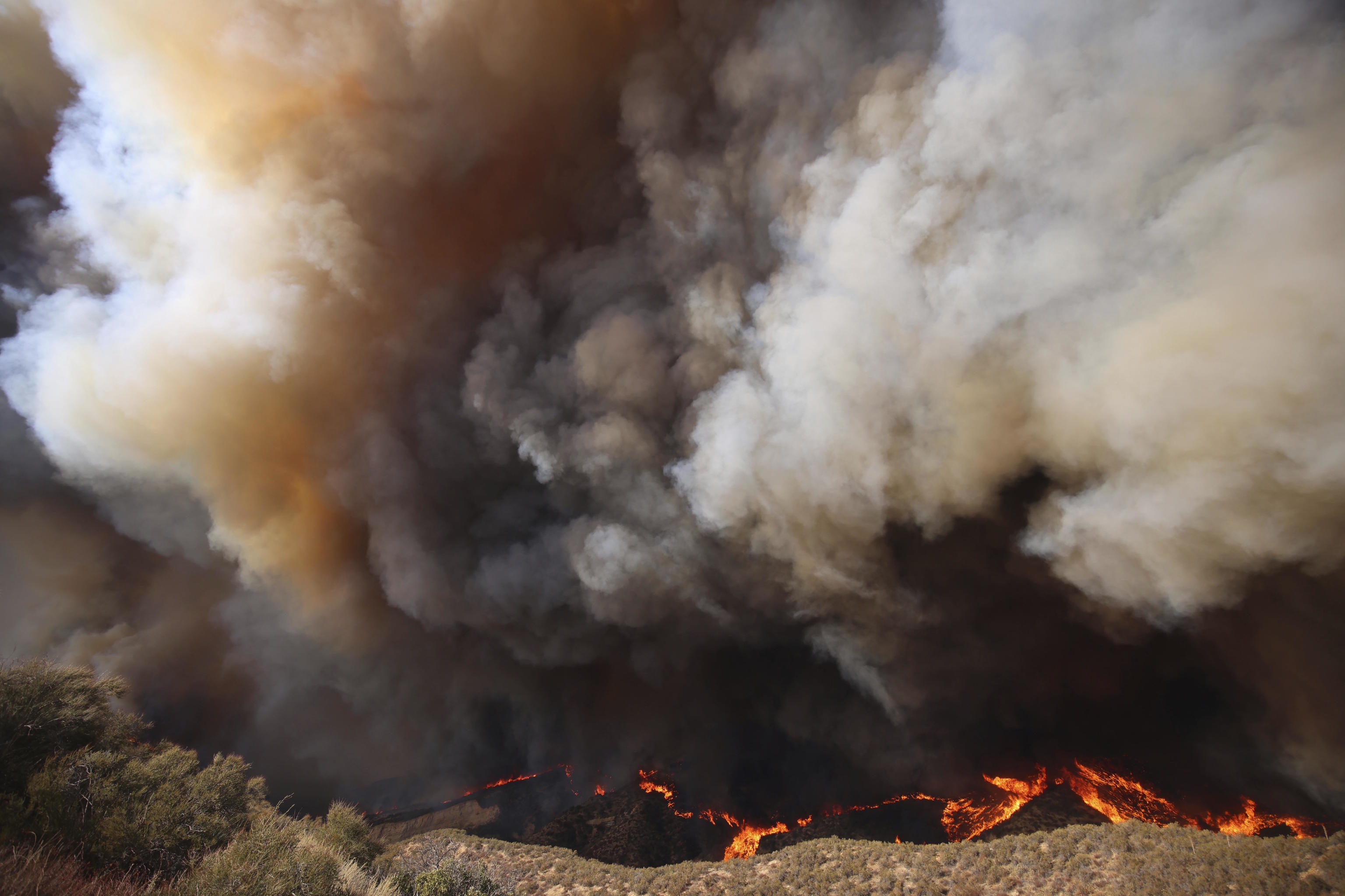 Plumes of smoke rise as the Hughes Fire burns in Castaic, Calif.