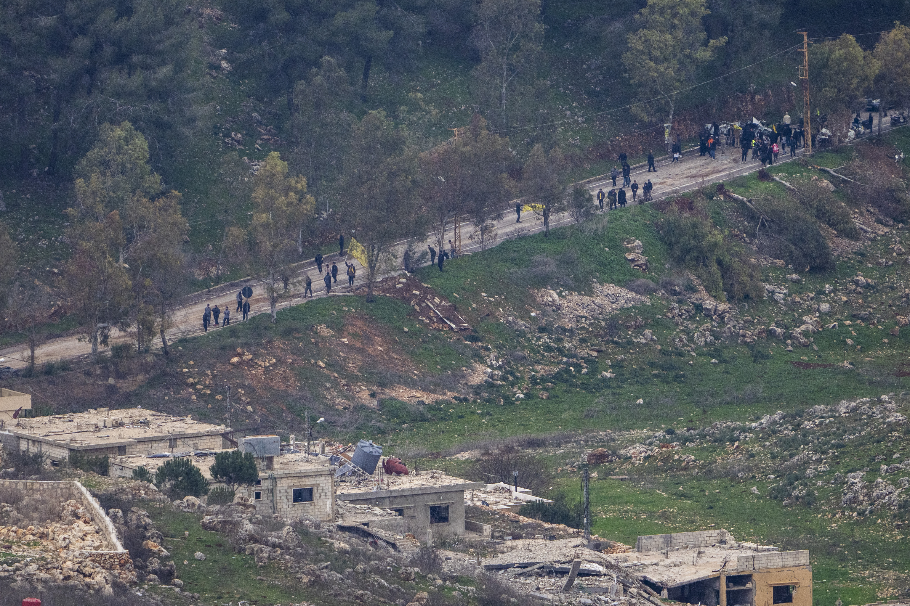 A group of people waves flags as they approach the outskirts of the southern Lebanese village of Al-Aadaissah, where Israeli soldiers continue to operate despite the ceasefire.