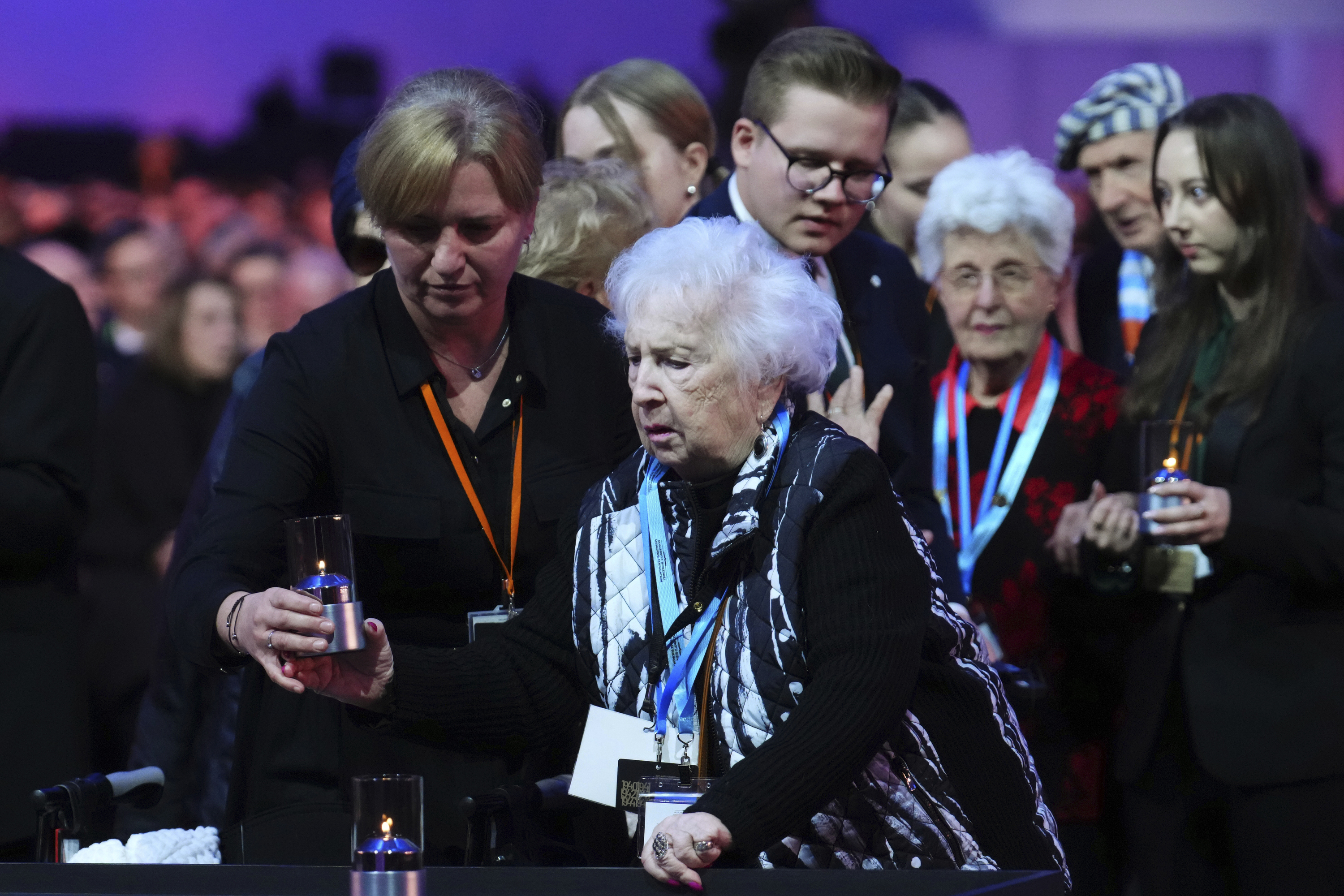 Canadian Holocaust survivor Miriam Ziegler, centre right, receives assistance as she places a candle during the Commemoration Ceremony of the 80th Anniversary of the Liberation of Auschwitz.