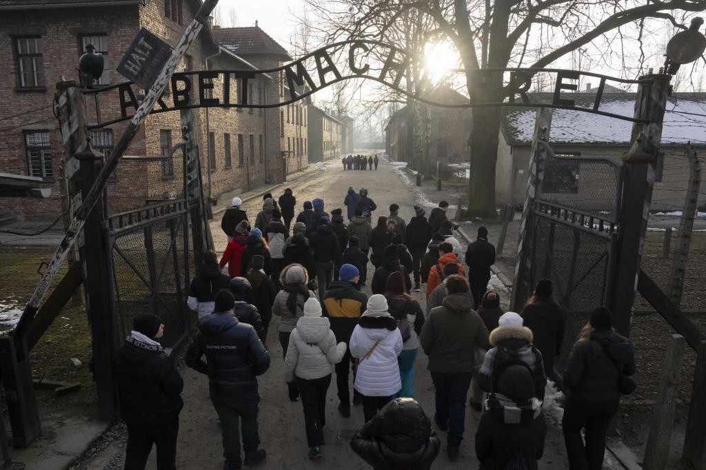 Visitors walk through the ''Arbeit Macht Frei" (Work Sets You Free) gate at the Memorial and Museum Auschwitz-Birkenau, a former Nazi German concentration and extermination camp