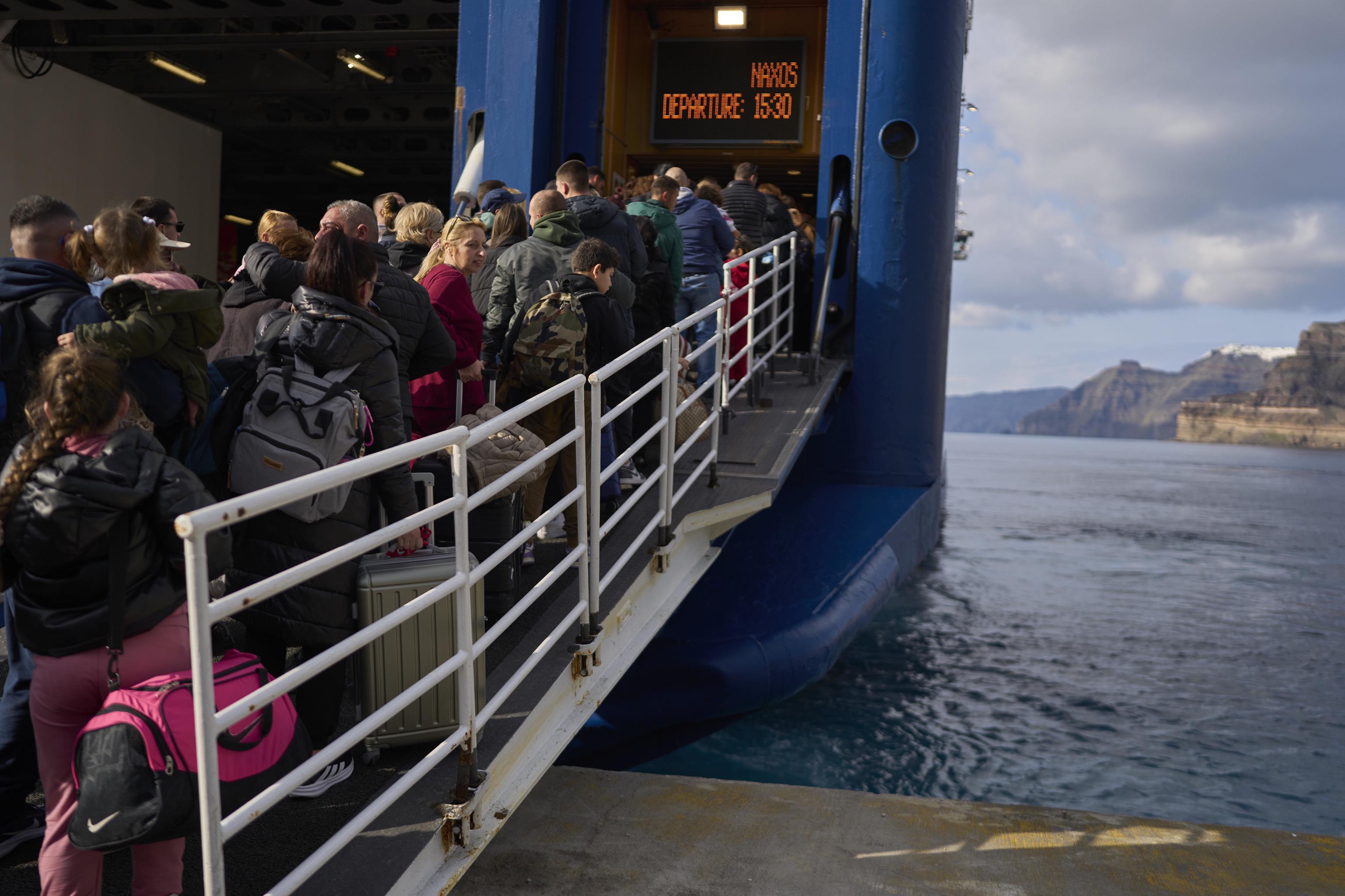 Passengers board a ferry to Athens after a spike seismic activity in Santorini.