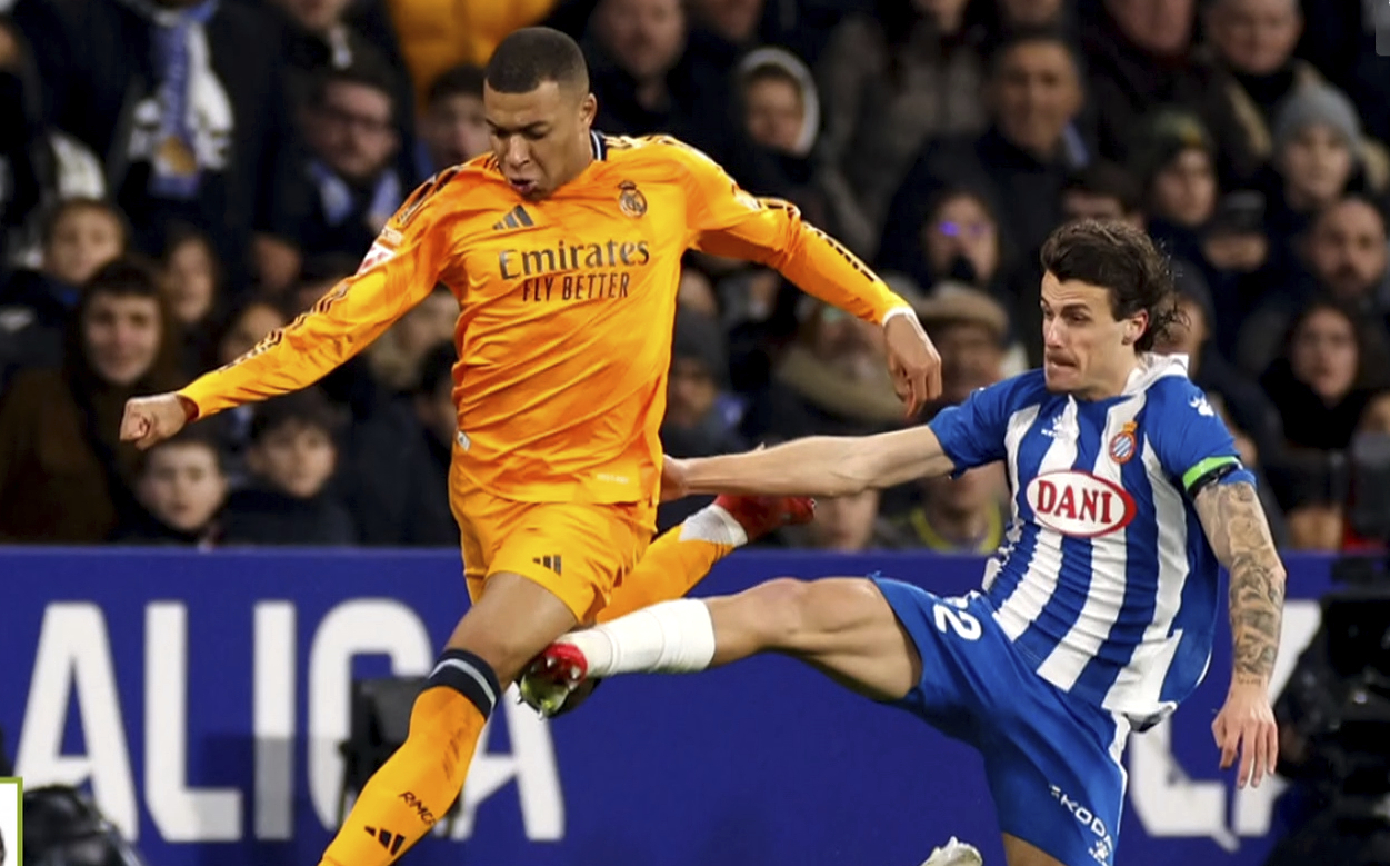 Real Madrid's Kylian Mbappe is tackled by Espanyol's Alex Kral.