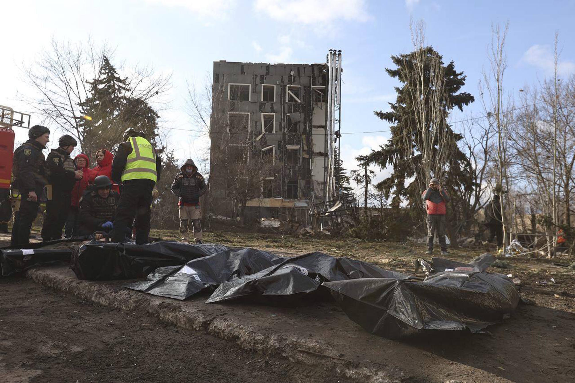 Policemen examine dead bodies, killed by a Russian strike in Izium.