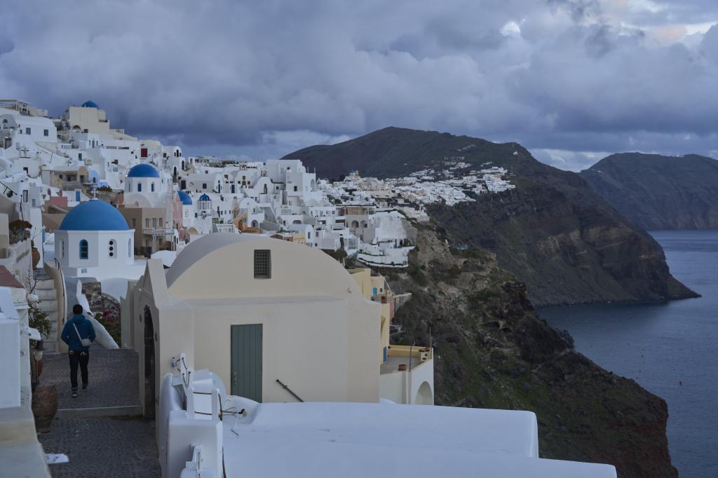 A tourist approaches blue-domed Orthodox churches in the town of Oia on the earthquake-struck island of Santorini