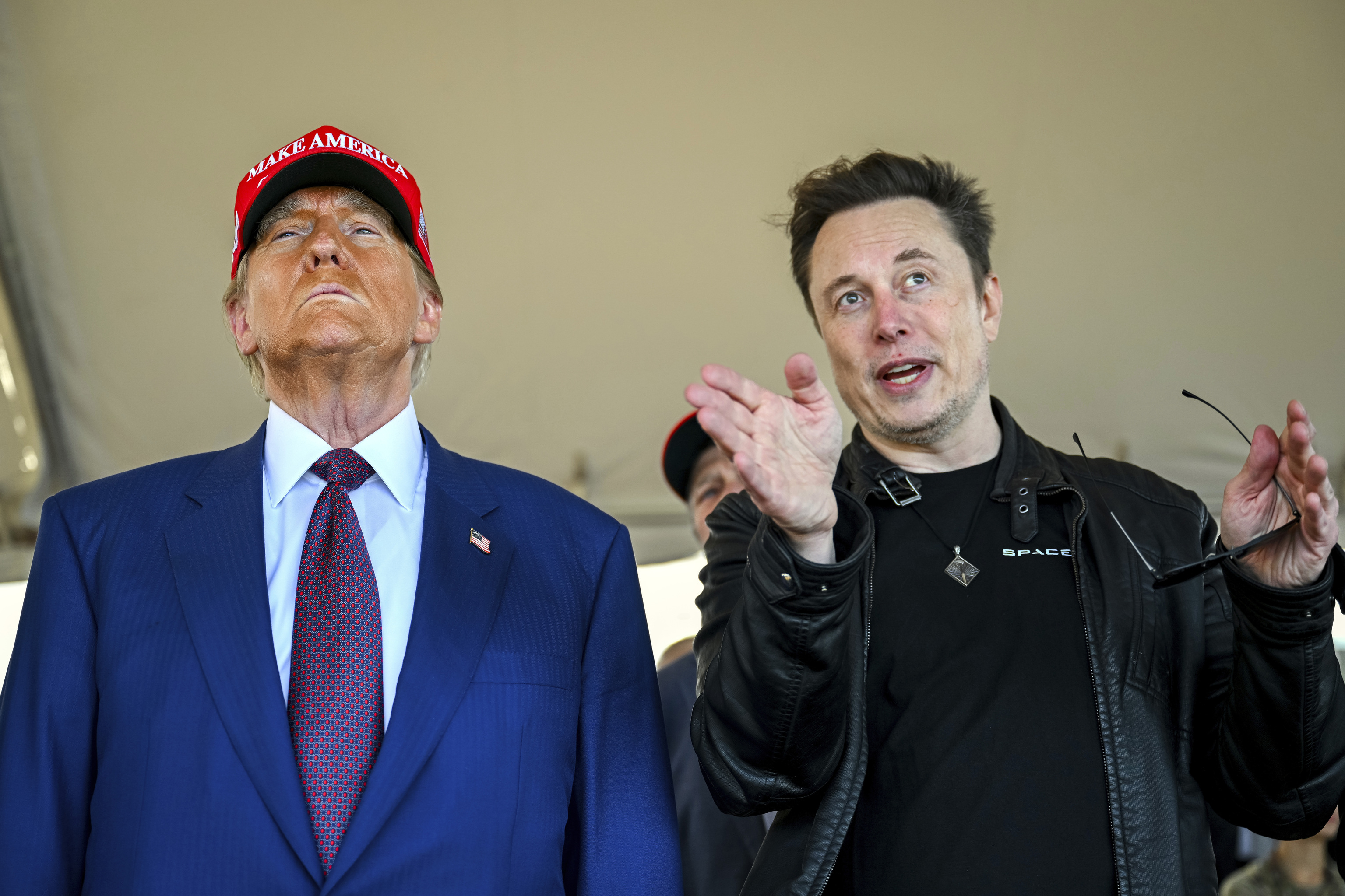 President-elect Donald Trump listens to Elon Musk.