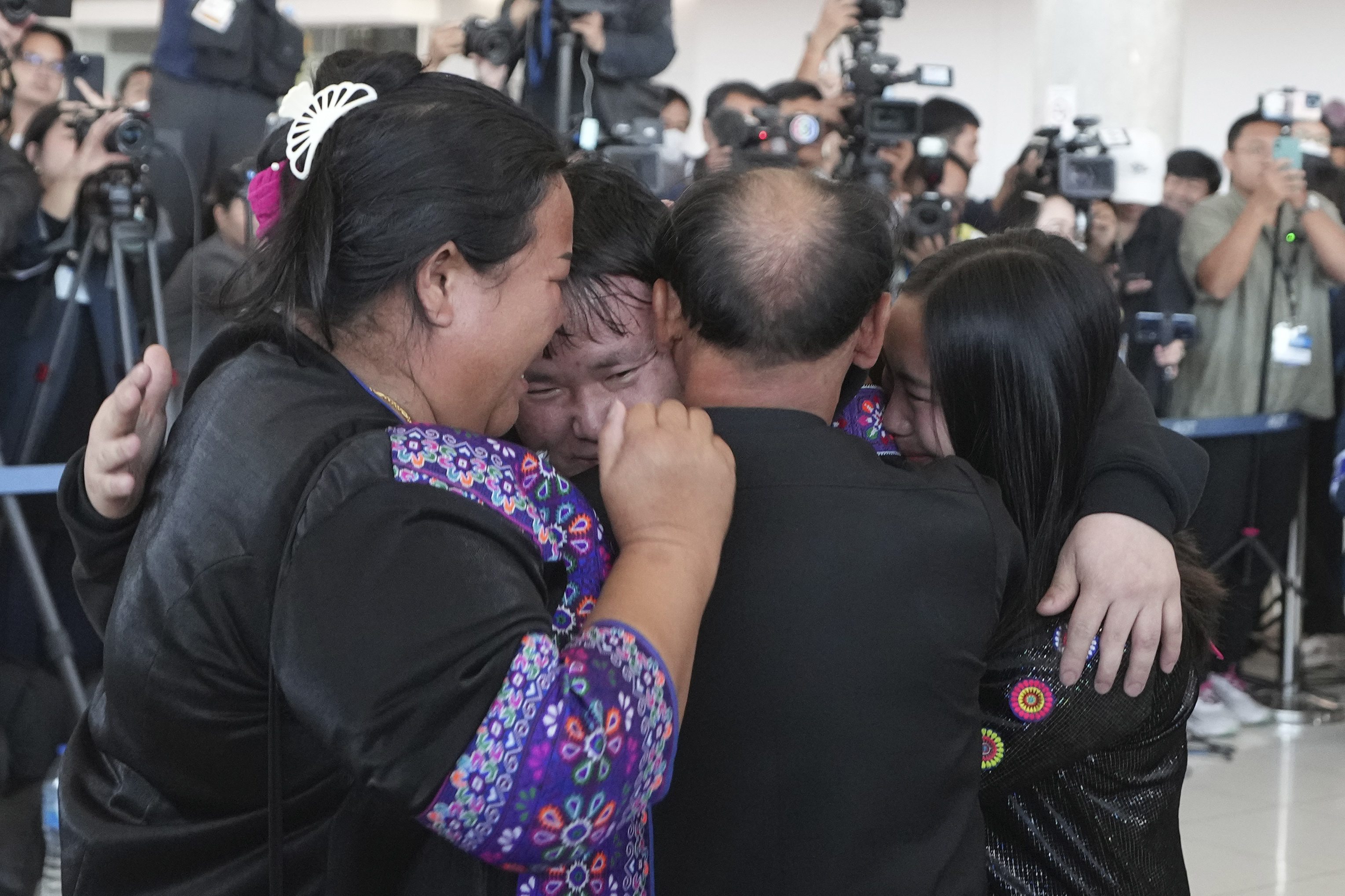 A Thai hostage who was freed from Hamas, Bannawat Saethao, second from left hugs relatives upon arrival at Suvarnabhumi International Airport.