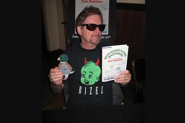 Tom Robbins with one of his books.