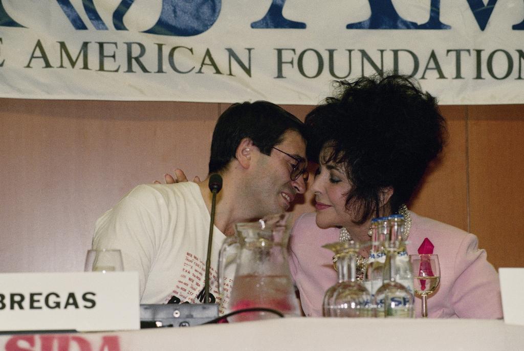 Actress Elizabeth Taylor, right, kisses Thomas Fabregas, who is HIV positive, after his speech at the International Conference on AIDS July 23, 1992