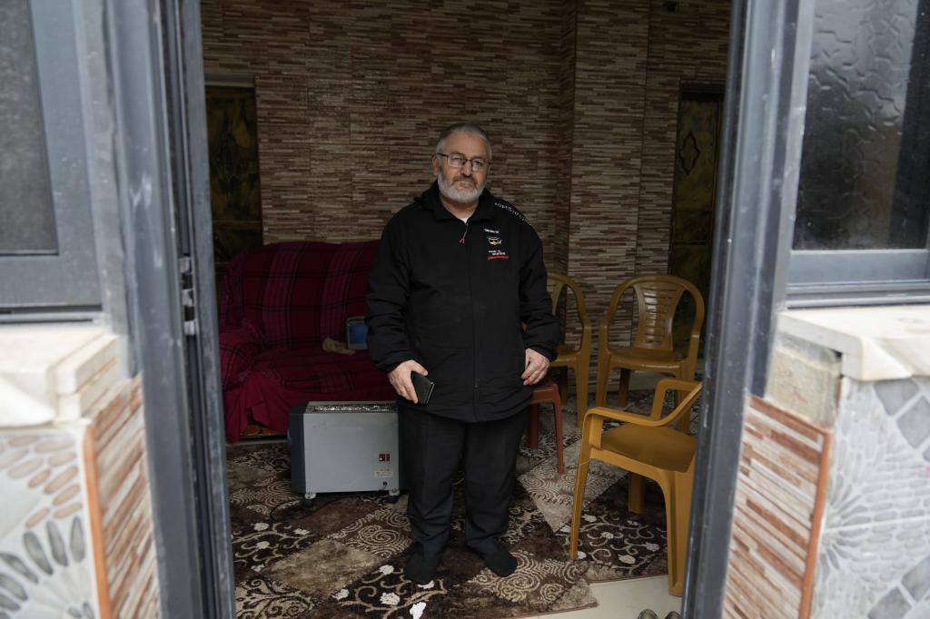 Mohammed Shula poses for a photo inside a relative's house where he and his wife have taken refuge at the West Bank village