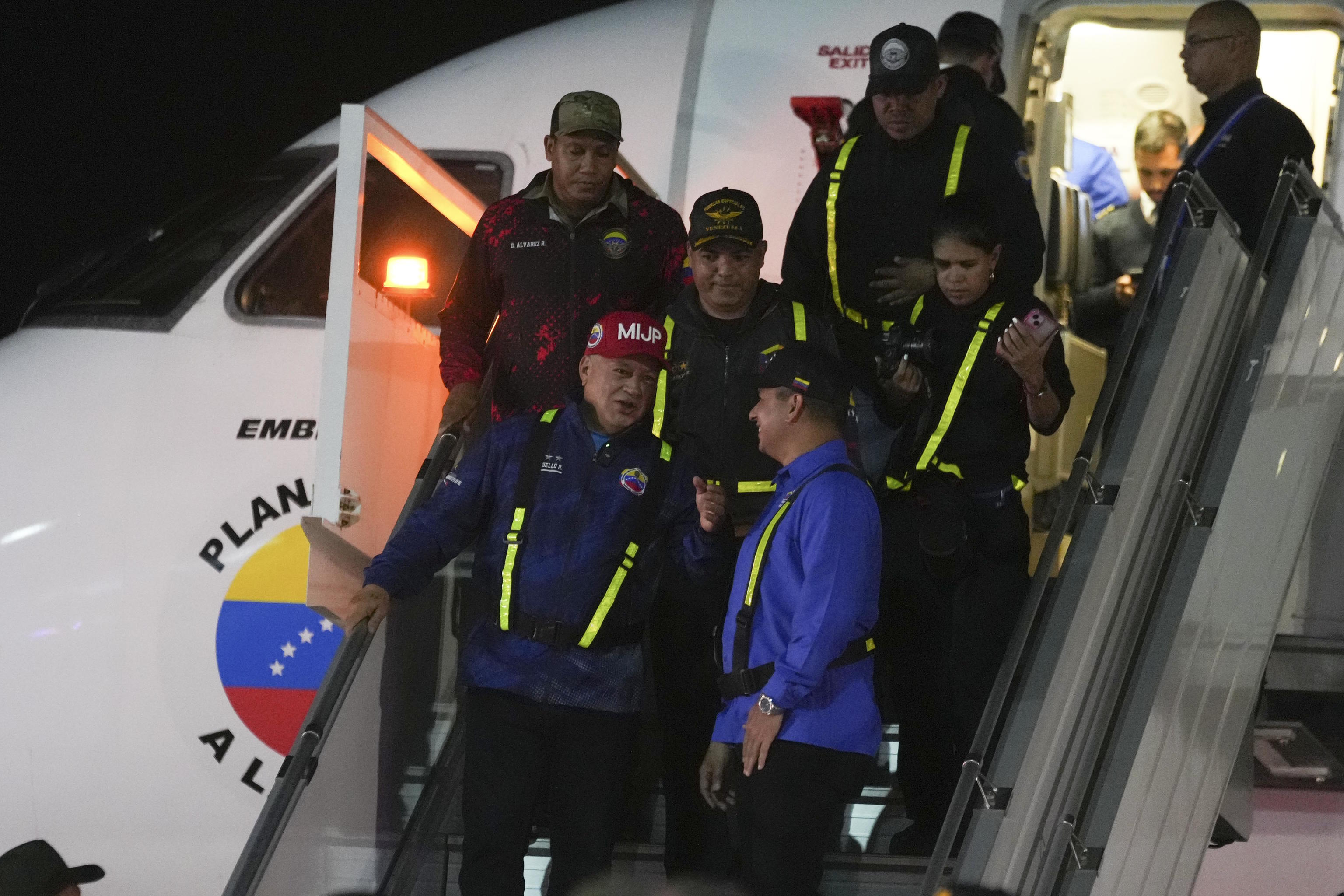 Diosdado Cabello walks off a plane that transported migrants deported.