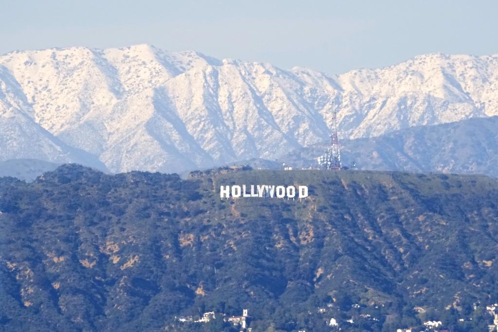 The Hollywood sign is seen with snow capped mountains behind it from the Baldwin Hills area of Los Angeles