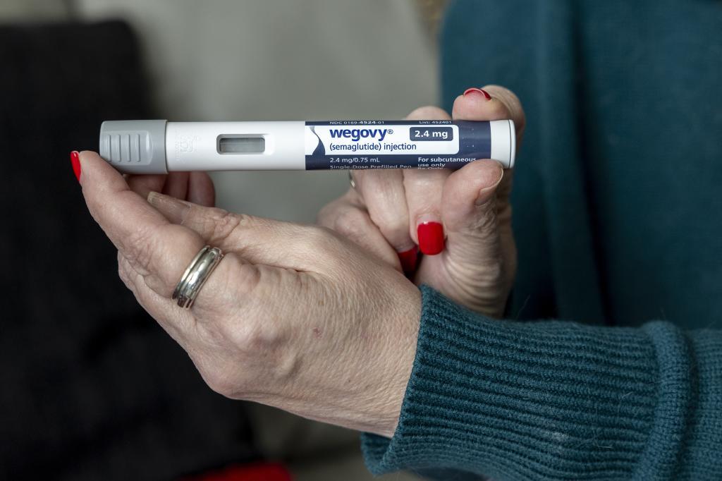 A woman holds up a dosage of Wegovy, a drug used for weight loss