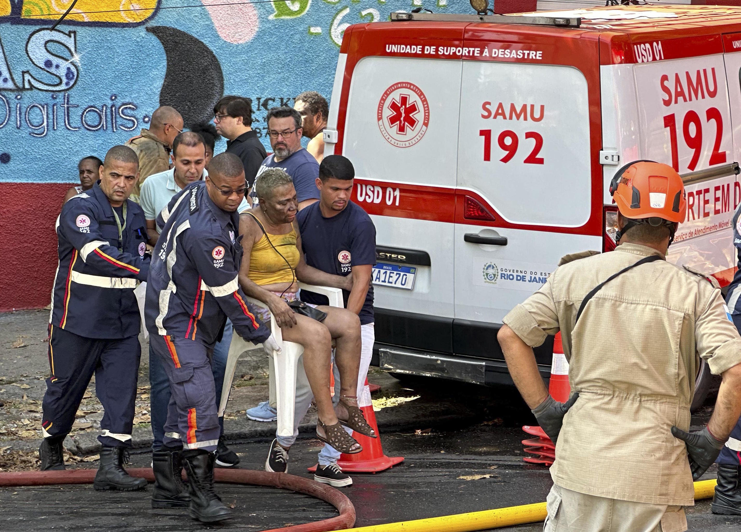 Medical personnel carry a woman injured in the fire.