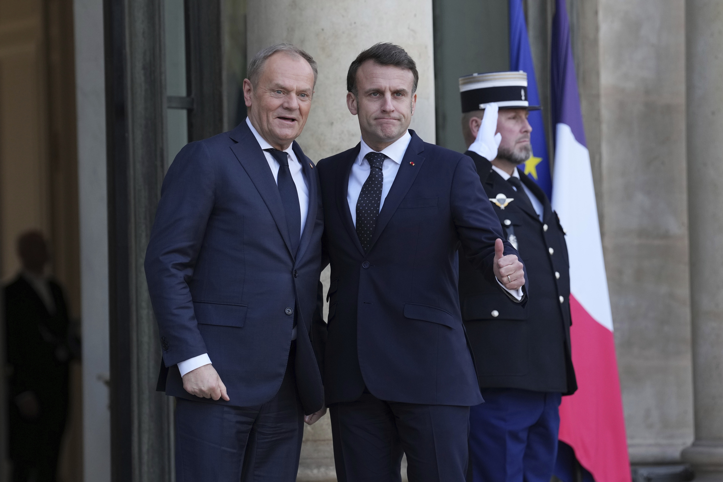 French President Emmanuel Macron, right, greets Poland's Prime Minister Donald Tusk.