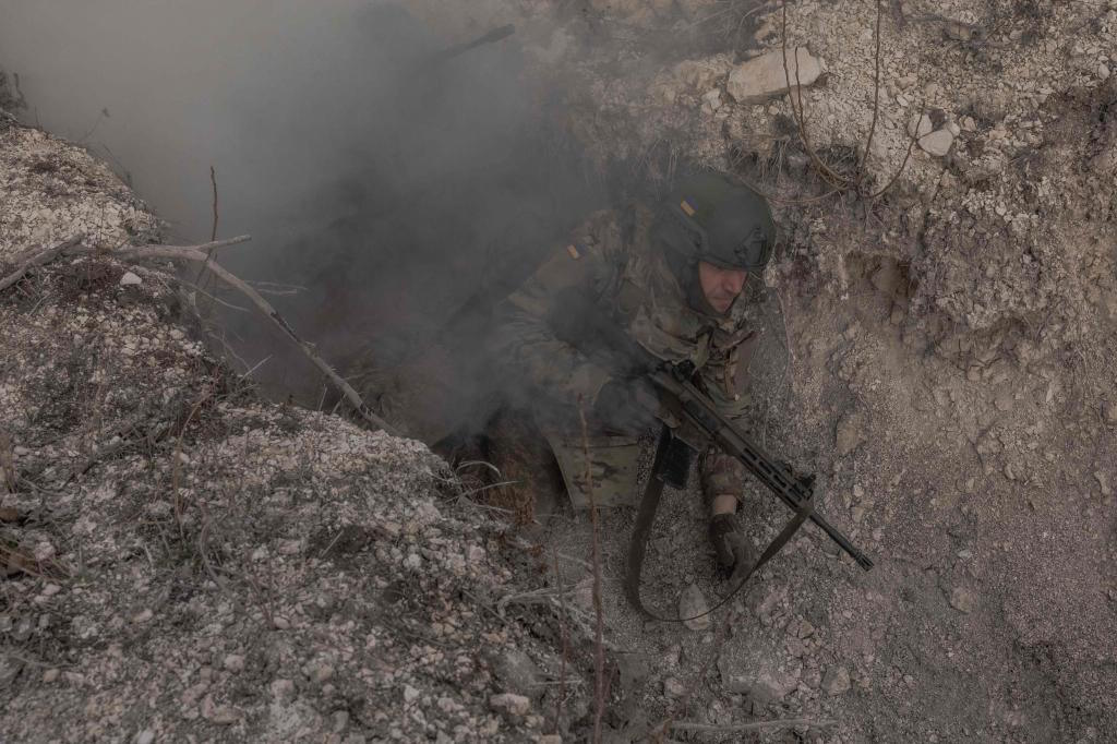 A Ukrainian serviceman of the Azov Brigade walks lies in a trench during a military training exercise.