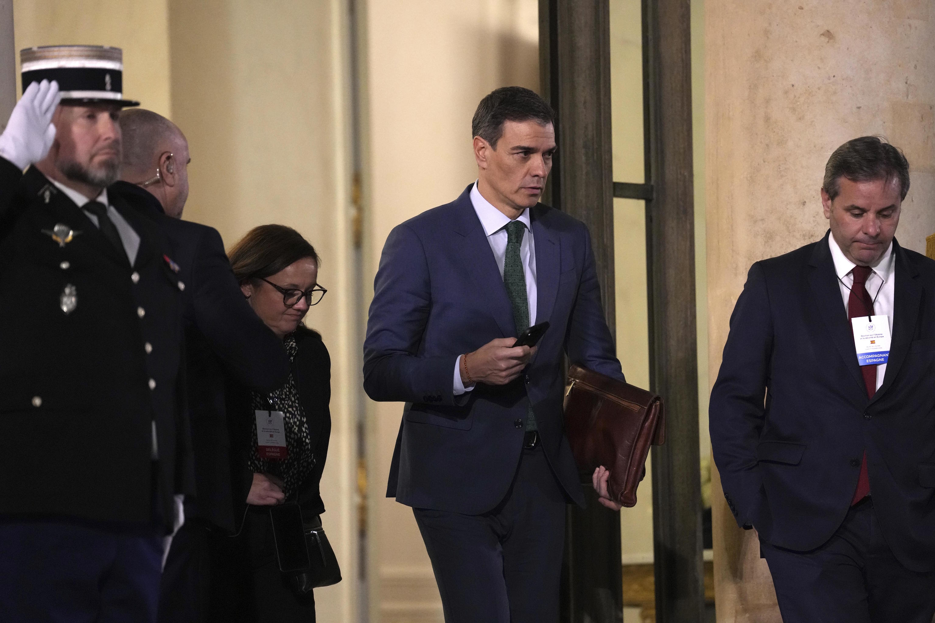 Spain's Prime Minister Pedro Sanchez, center, leaves the Elysee Palace.