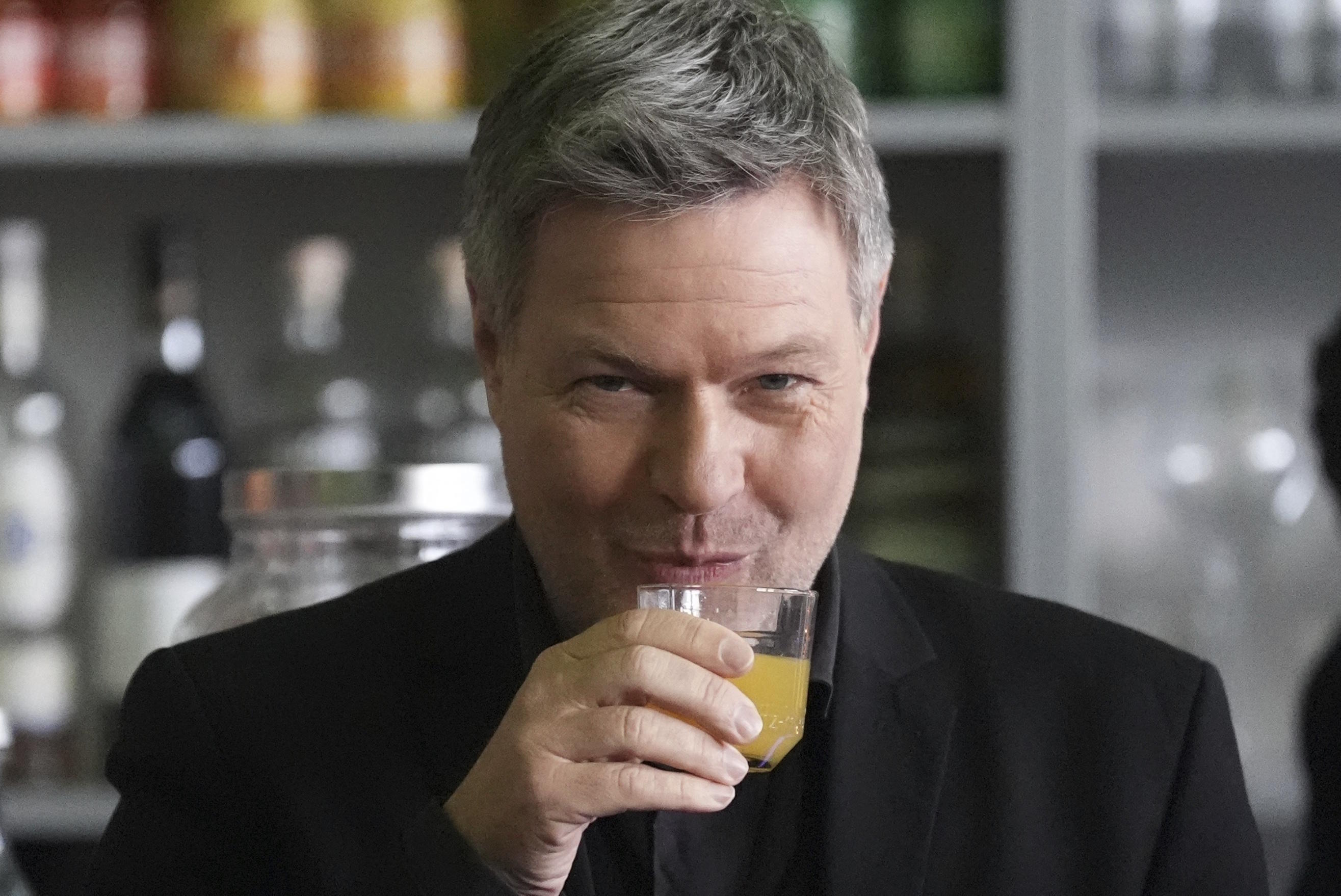 Robert Habeck drinks orange juice before an election rally in Flensburg.