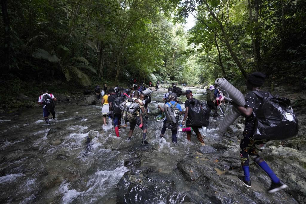 Migrants cross the Acandi River on their journey  from Colombia into Panama.