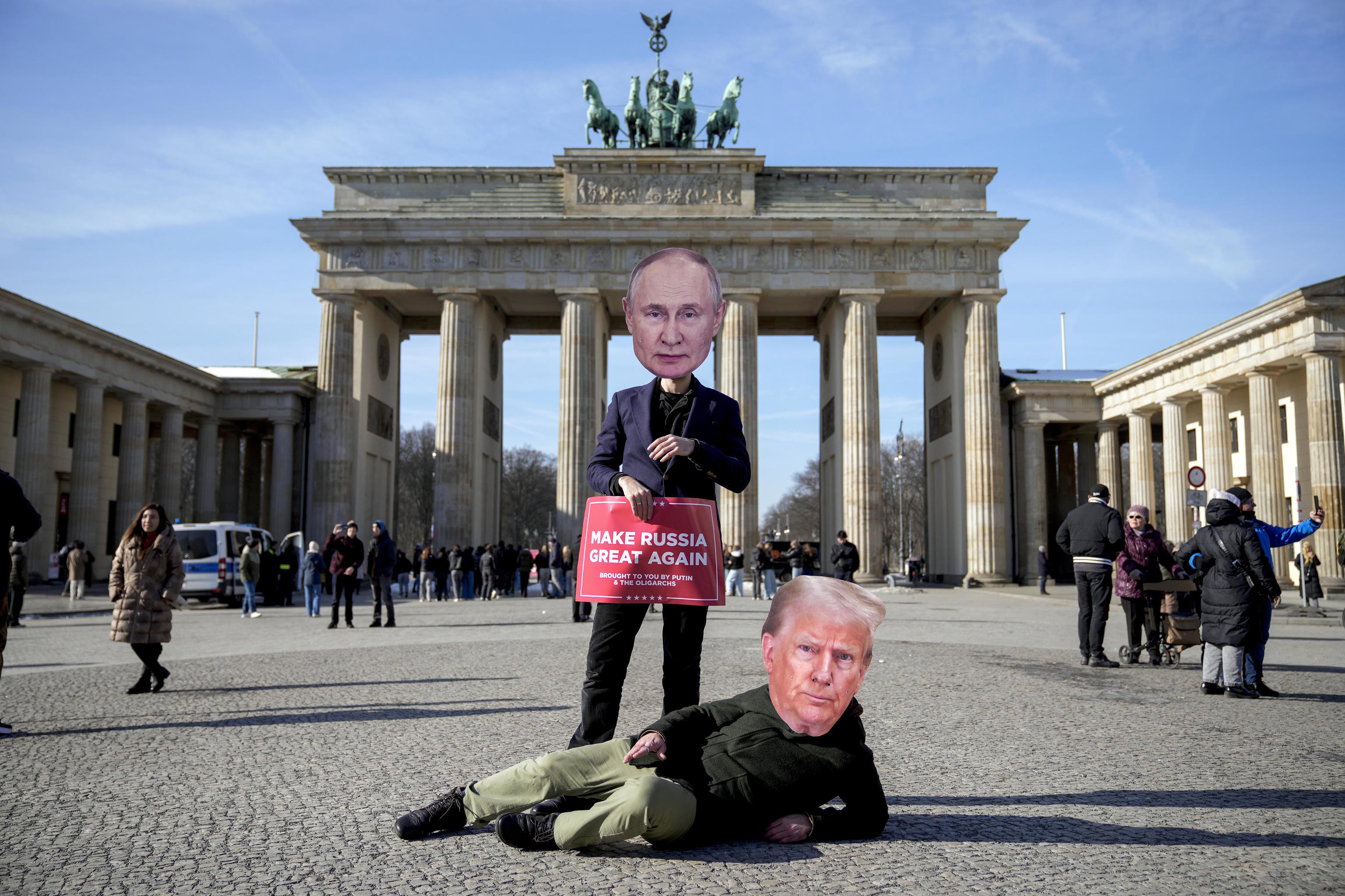 Activists wearing masks of US President Trump, down, and Putin.